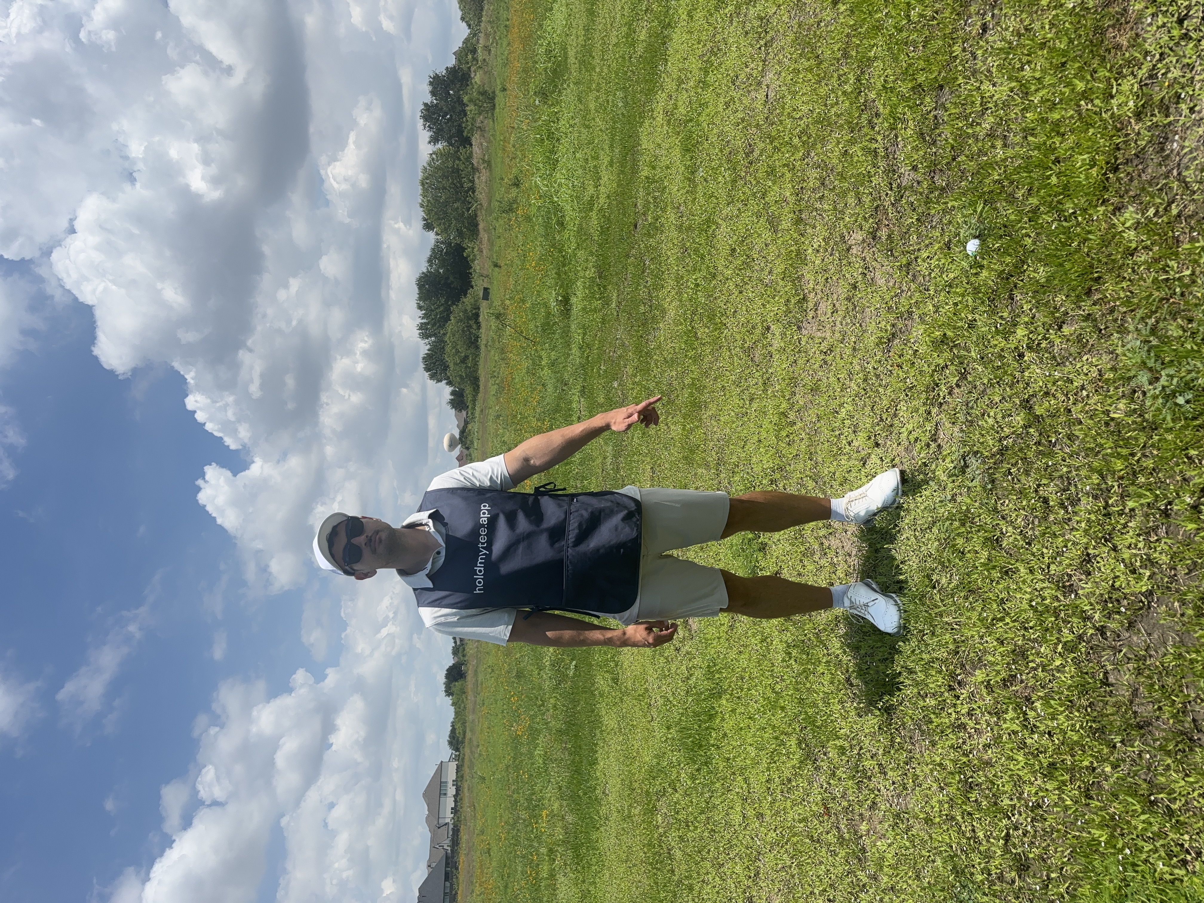 Spotter standing over a golfer's ball on the fairway